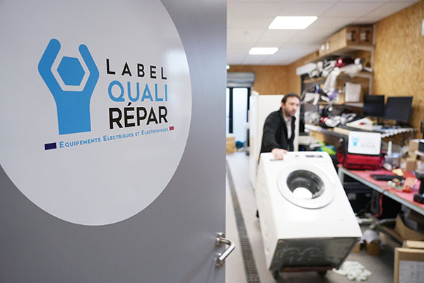 Macaron du Label QualiRépar sur la porte d'un réparateur